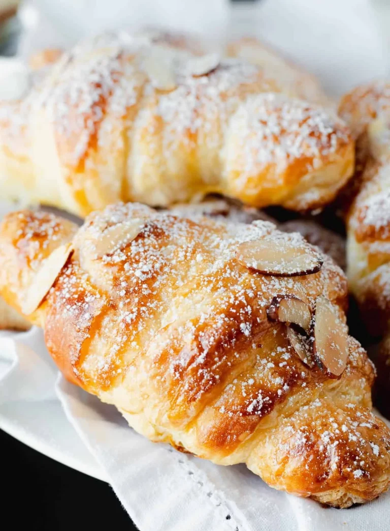 Delicious almond cream filled croissants on a rustic wooden table.
