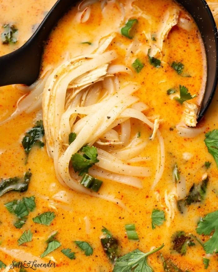 Bowl of Thai inspired chicken soup with herbs and spices.