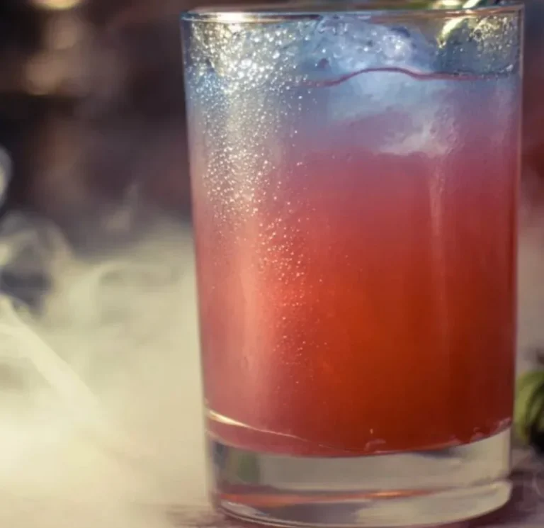 A spooky Witches Brew Drink with vibrant colors and garnishes, perfect for Halloween.