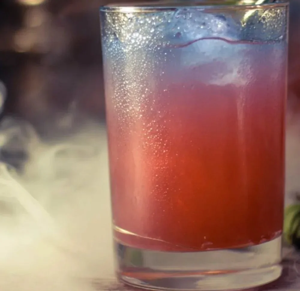 A spooky Witches Brew Drink with vibrant colors and garnishes, perfect for Halloween.