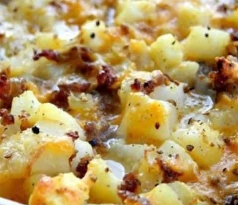 Cheesy potato breakfast casserole baked in a dish, topped with golden cheese.
