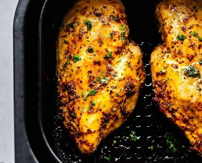 Delicious air fryer chicken breasts garnished with herbs and spices