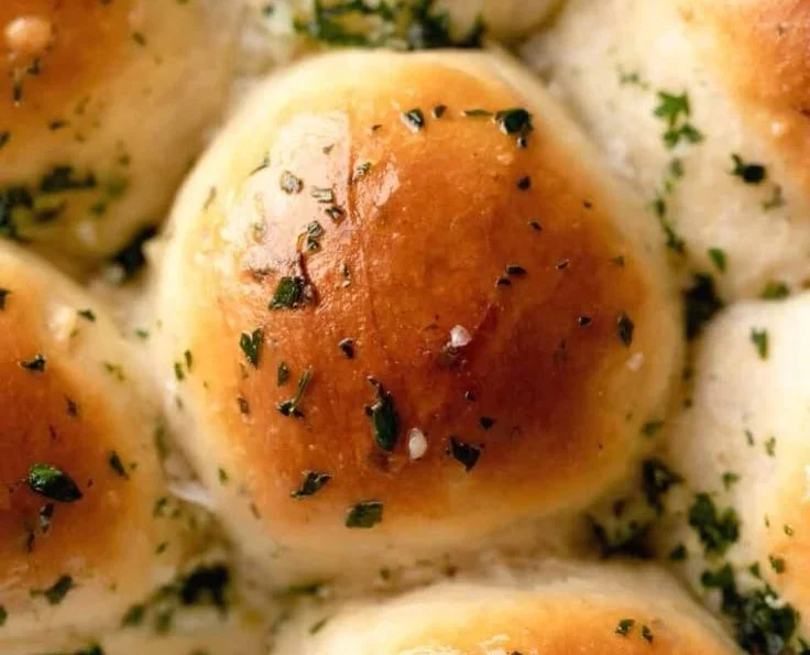 Freshly baked garlic bread rolls served warm with herbs and butter
