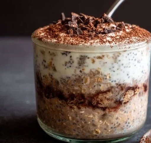Bowl of high protein tiramisu overnight oats topped with cocoa and coffee beans