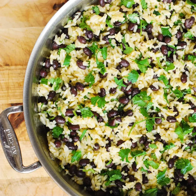 Bowl of cilantro-lime black bean rice garnished with fresh cilantro and lime