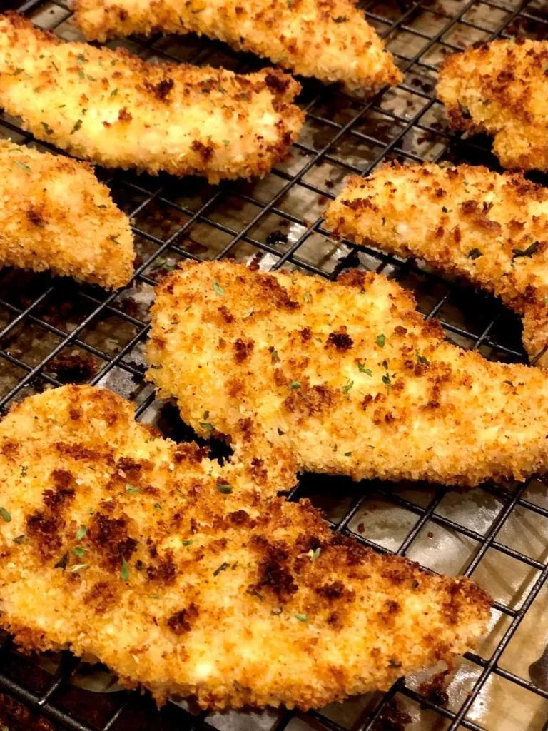 Spicy baked chicken strips served on a plate with dipping sauce