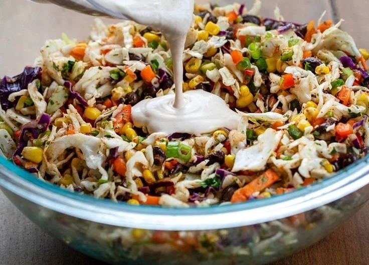 Bowl of easy cole slaw with fresh vegetables and dressing