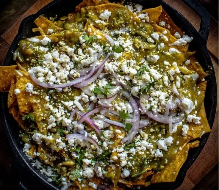 Plate of Green Chilaquiles topped with avocado and cilantro