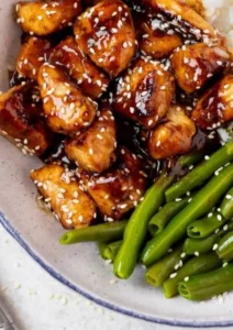 Healthy sesame chicken served with vegetables and garnished with sesame seeds